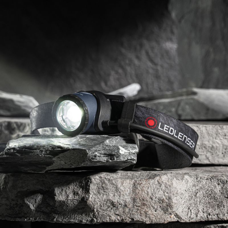 Ledlenser H8R 25th Anniversary Edition resting on pile of granite. Switched on.
