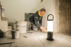 Tiler working with grout and using the Ledlenser AL10R lantern to light his work surface