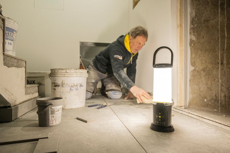 Tiler working with grout and using the Ledlenser AL10R lantern to light his work surface
