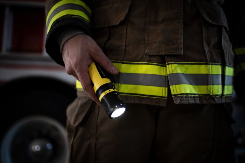 Firefighter using the Ledlenser EX7R rechargeable torch to light their way on the job