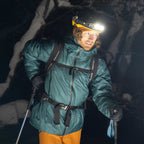 Person in winter gear with a Ledlenser H19R Signature headlamp on a snowy mountain at night