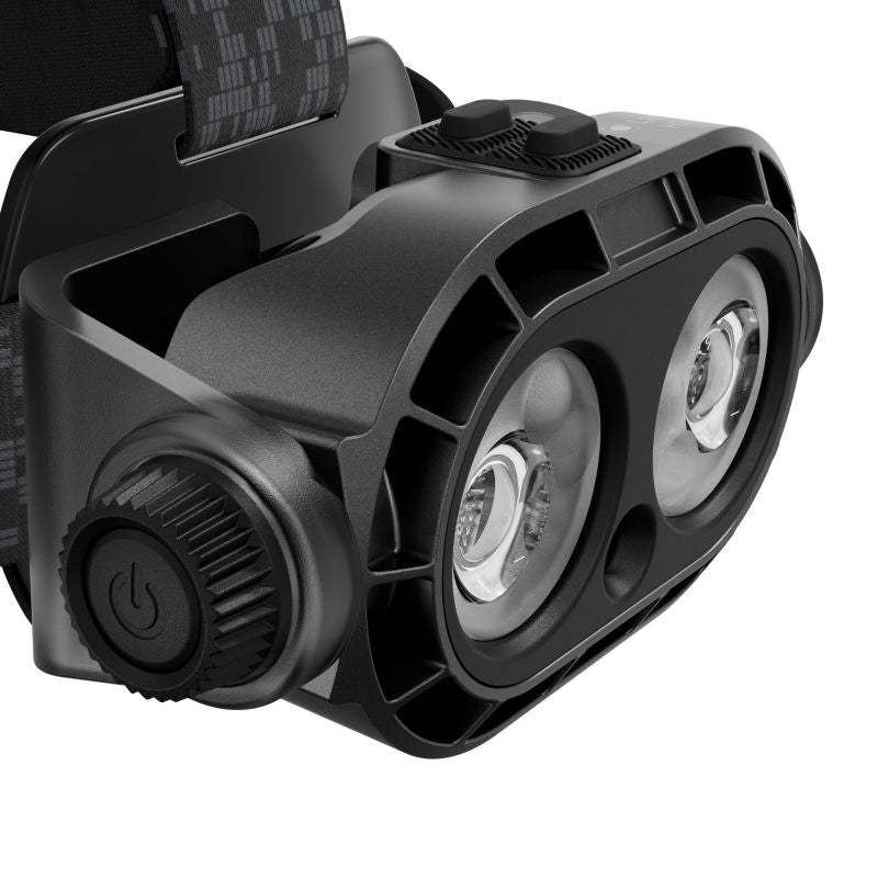 A close-up of a Ledlenser H21R headlamp with dual LED light modules, a textured power button, and a black adjustable strap on a white background.