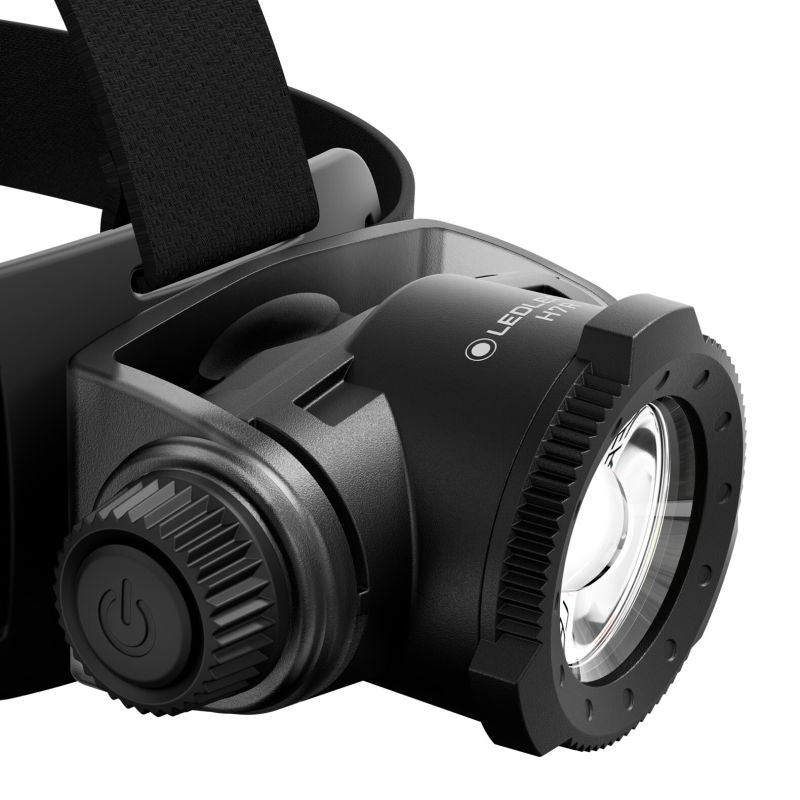 Close up of the head unit on a Ledlenser H7R headlamp with on/off switch to the left and focus dial at from of lense