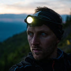 Person wearing a Ledlenser H7R Core headlamp in a mountainous landscape during dusk.