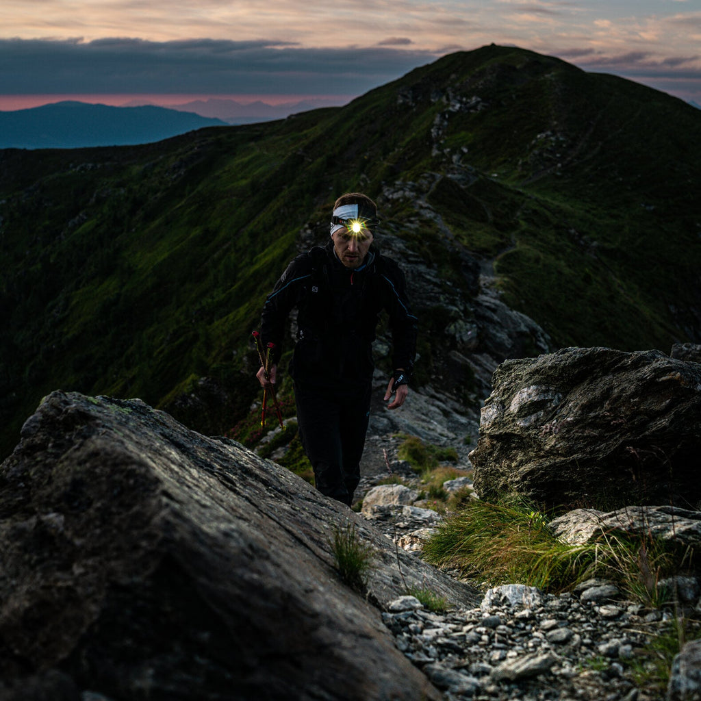 Person using Ledlenser H7R Core rechargeable headlamp to light the trail ahead of them