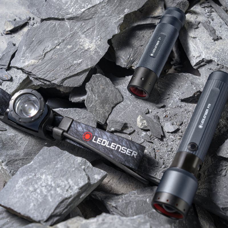 Overhead view of Headlamp H8R 25th Anniversary Edition resting on granite next to Ledlenser P7R Anniversary torch
