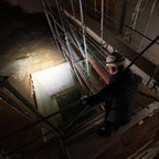 Man in white hardhat with HF8R Work Headlamp using it to illuminate a darkened worksite