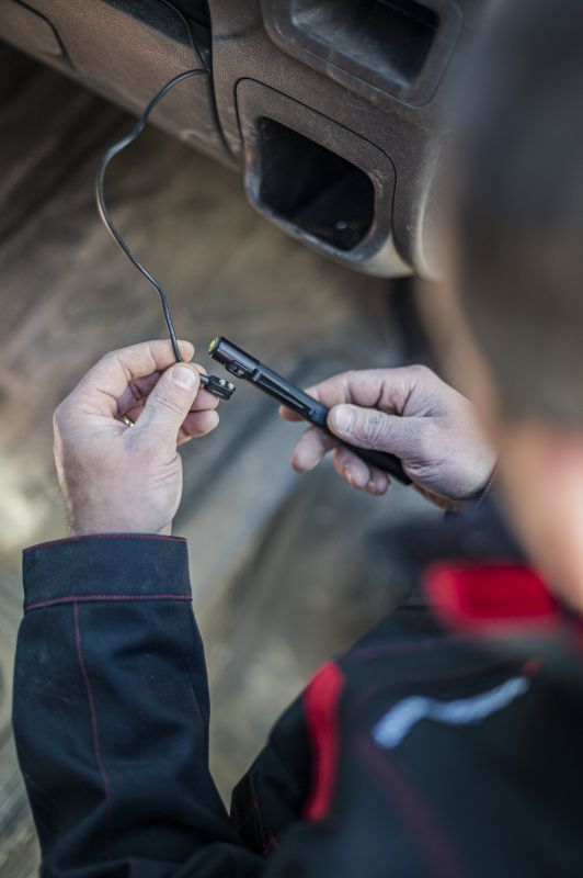 Image of person about to connect the magnetic charging cable to their Ledlenser P4R Work torch 