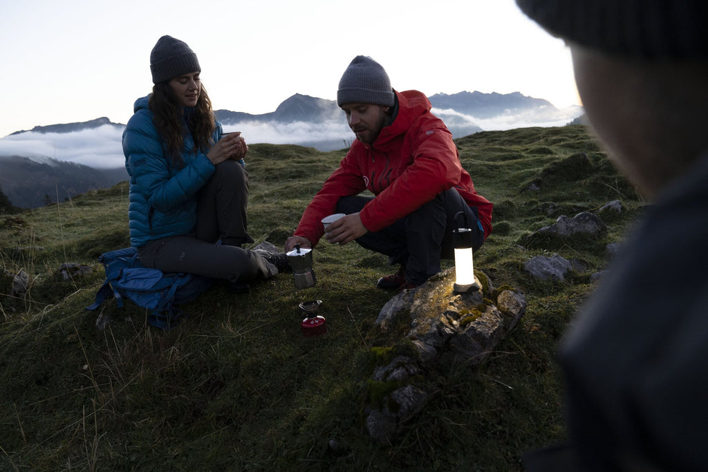 Two people sitting in camp using the Ledlenser ML6 Rechargeable Lantern
to light their way