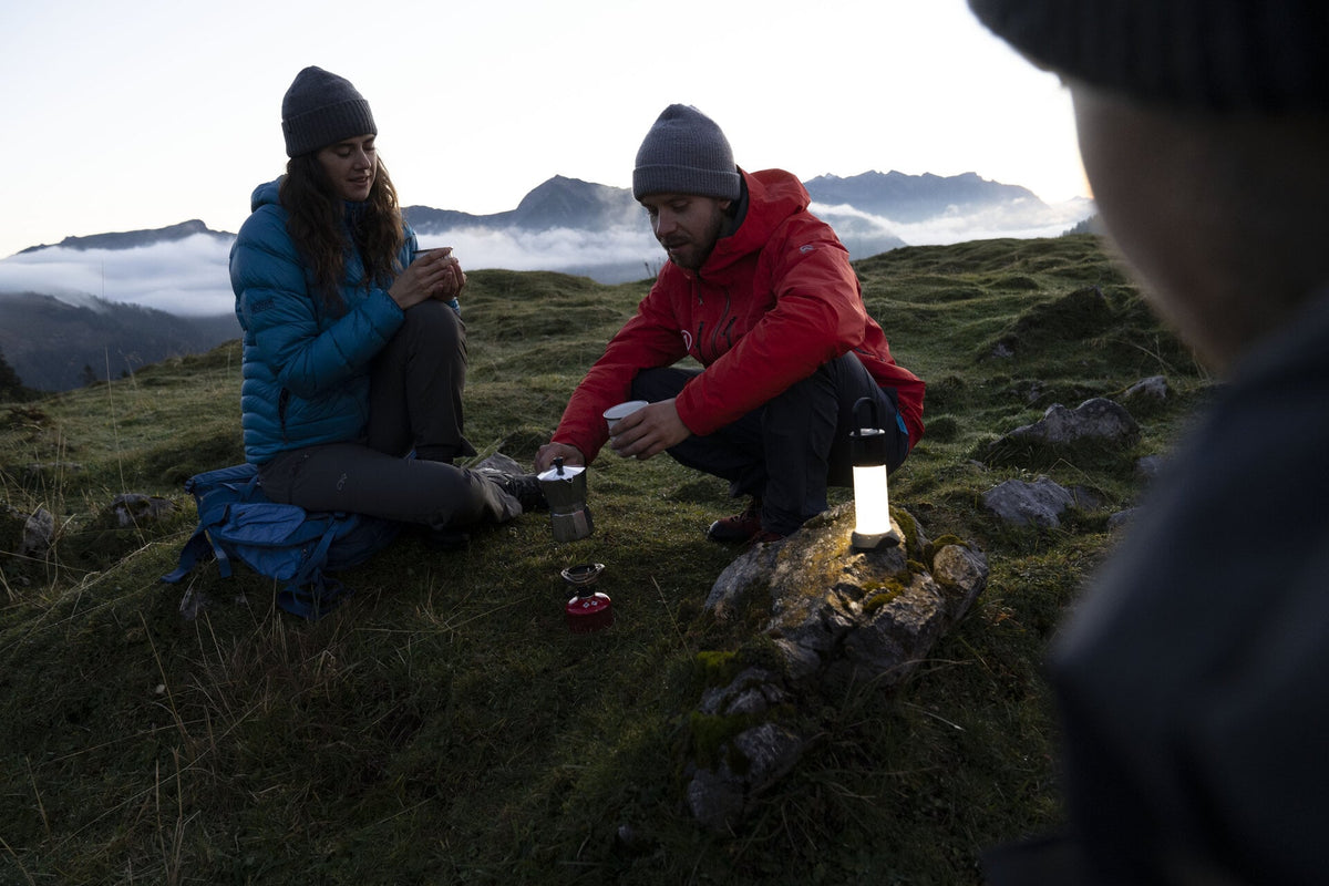 Two people sitting in camp using the Ledlenser ML6 Rechargeable Lantern
to light their way