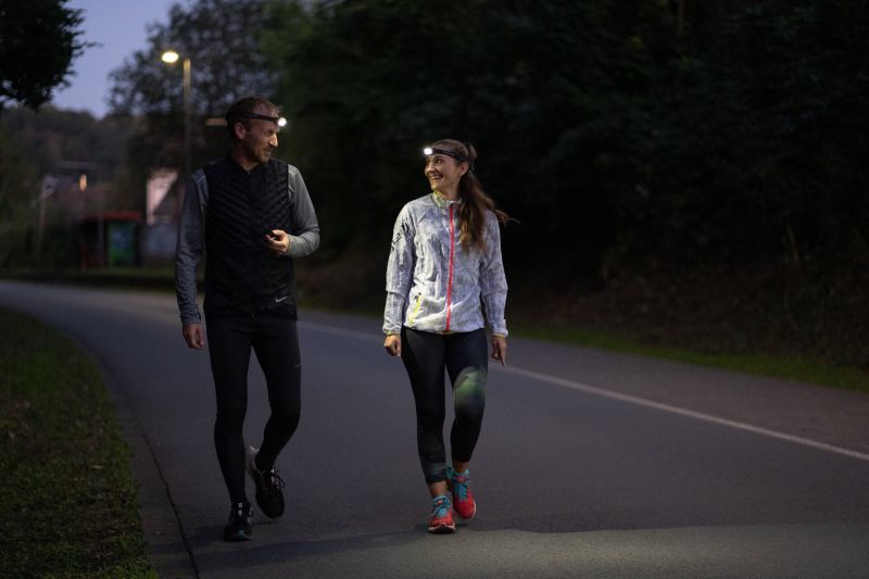 Image of couple lighting their way on a walk at dusk using the Ledlenser NEO3 headlamp with reflective headband – Blue 