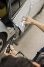Mechanic using Ledlenser W4R rechargeable work light to highlight inside of car door