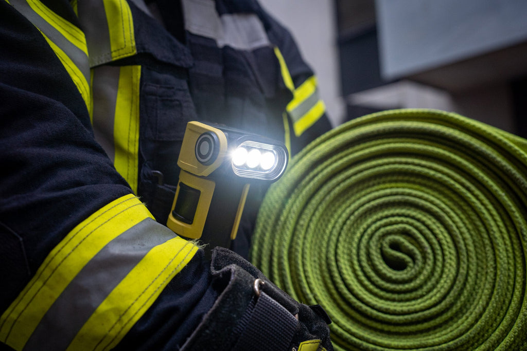 Firefighter using the Ledlenser ultra-compact, yellow and black EXC7R rechargeable torch while on the job