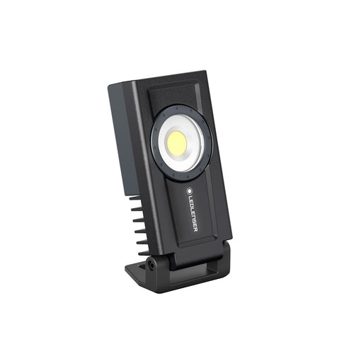 Three quarter front left right view of rectangular Ledlenser If3R rechargeable work light  with stand engaged - Black
