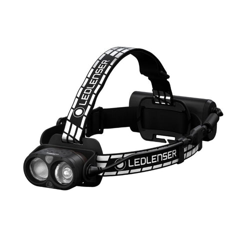 Three quarter front view of Ledlenser H19R Signature rechargeable headlamp with dual light sources, black/white branded overhead strap and battery pack - Black